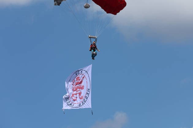 Kassel, Deutschland 01. August 2026: Testspiel - 2026 2027 - KSV Hessen Kassel gegen FC Schalke 04 Im Bild: Fallschirmspringer KSV Hessen Kassel mit Fanfahne von Hessenkassel am Himmel. Auestadion Hessen *** Kassel, Germany, August 1, 2026; 2026-2027 Friendly Match: KSV Hessen Kassel vs. FC Schalke 04. Pictured: KSV Hessen Kassel skydivers with a Hessenkassel fan flag in the sky above the Auestadion in Hessen. Copyright: xFotostandx xFabianxWernerx