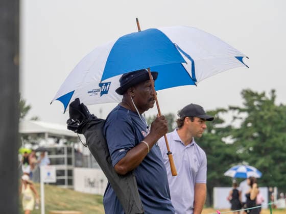 DETROIT, MI - AUGUST 01: A spectator shields from the rain under an umbrella during the third round of the Rocket Classic at Detroit Golf Club on August 01, 2026, in Detroit, Michigan. (Photo by Joseph Weiser Icon Sportswire) GOLF: AUG 01 PGA, Golf Herren Rocket Classic EDITORIAL USE ONLY Icon2608010643