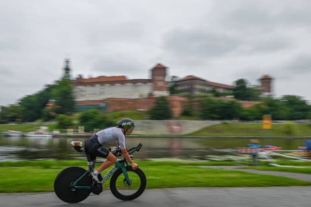 TRIATHLON: Stepniak And Bartlett Secure Elite Victories At IRONMAN 70.3 Krakow KRAKOW, POLAND - AUGUST 02: A female elite professional triathlete speeds along the Vistula River boulevard on her time-trial bicycle with the historic Wawel Royal Castle in the background during the 90-kilometer cycling stage of the Enea IRONMAN 70.3 Krakow triathlon in Krakow, Lesser Poland Voivodeship, Poland, on August 02, 2026. The professional elite field completed a high-speed bike route looping through the region before returning to the city center for the final run discipline. Krakow Poland  Copyright: xArturxWidakx originalFilename:widak-triathlo260802_npccf.jpg