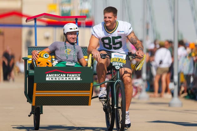 Green Bay Packers Training Camp 2026 Tucker Kraft 85 of the Green Bay Packers rides a bicycle with a young fan in the passenger seat during the Green Bay Packers training camp at Ray Nitschke Field in Ashwaubenon, Wisconsin, on August 2, 2026. Ashwaubenon Wisconsin United States  Copyright: xRossxHarriedx originalFilename:harried-greenbay260802_npQRS.jpg