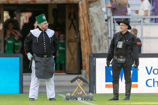 GER, Aue, Fussball, Regionalliga Nordost, 3. Spieltag, FC Erzgebirge Aue vs. BFC Dynamo im Bild v.l.: Bergleute stehen vor dem Spiel auf dem Feld und Warten auf das traditionelle Steigerlied vor dem Anpfiff 06.08.2026, EINS Erzgebirgsstadion Aue DFB REGULATIONS PROHIBIT ANY USE OF PHOTOGRAPHS AS IMAGE SEQUENCES AND OR QUASI-VIDEO, *** GER, Aue, Soccer, Northeast Regional League, Matchday 3, FC Erzgebirge Aue vs. BFC Dynamo: In the photo, from left, miners stand on the field before the game, waiting for the traditional Steigerlied to be sung before kickoff, August 6, 2026, EINS Erzgebirgsstadion Aue DFB REGULATIONS PROHIBIT ANY USE OF PHOTOGRAPHS AS IMAGE SEQUENCES AND OR QUASI-VIDEO, Copyright: HMBxMedia PaulxFritz