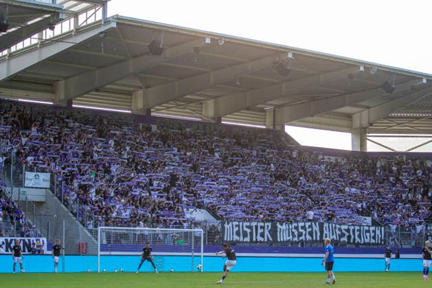 GER, Aue, Fussball, Regionalliga Nordost, 3. Spieltag, FC Erzgebirge Aue vs. BFC Dynamo im Bild v.l.: Heimfans, Ultrablock Erzgebirge Aue mit Spruchbanner Meister muessen aufsteigen, Protest gegen den NOFV , Aufstiegsreform zum Aufstieg in die 3. Liga 06.08.2026, EINS Erzgebirgsstadion Aue DFB REGULATIONS PROHIBIT ANY USE OF PHOTOGRAPHS AS IMAGE SEQUENCES AND OR QUASI-VIDEO, *** GER, Aue, Soccer, Northeast Regional League, Matchday 3, FC Erzgebirge Aue vs. BFC Dynamo: Pictured from left, home fans; Erzgebirge Aue ultra block with a banner reading Champions Must Be Promoted ; protest against the NOFV; promotion reform for promotion to the 3rd League, August 6, 2026; EINS Erzgebirgsstadion Aue DFB REGULATIONS PROHIBIT ANY USE OF PHOTOGRAPHS AS IMAGE SEQUENCES AND OR QUASI-VIDEO, Copyright: HMBxMedia PaulxFritz