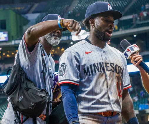 Minnesota Twins coach Ta Troy Hawkins (L) pours water on Minnesota Twins shortstop Kaelen Culpepper as he is interviewed after the MLB, Baseball Herren, USA game between the Minnesota Twins and the Milwaukee Brewers at American Family Field in Milwaukee, Wisconsin on Friday, August 7, 2026. The Twins defeated the Brewers 8-6. Culpepper got his first Major League hit in the game, a home run.  MIL20260807849 TANNENxMAURY