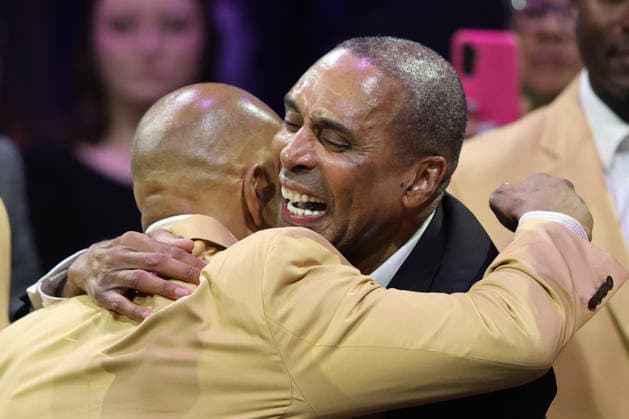 2026 pro football hall of fame inductee, Roger Craig hugs a hall of famer on his way to receive his gold jacket at a ceremony in Canton, Ohio, on Friday, August 7, 2026.  CAN20260807137 AARONxJOSEFCZYK