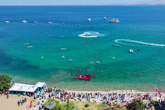 12th Van Sea Water Sports Festival kicks off on Lake Van VAN, TURKIYE - AUGUST 08: An aerial view of divers unfurling a large Turkish flag as participants and athletes taking part in the 12th Van Sea Water Sports Festival held at the Edremit-Gebze Water Sports Center on the shores of Lake Van in Van, Turkiye, on August 08, 2026. Organized to promote Lake Van and boost local tourism, the two-day event features Beach volleyball, Beachvolleyball and handball matches, flyboard demonstrations, canoeing, rowing, dragon boat races, and various recreational activities. Ozkan Bilgin Anadolu Van Turkey. Editorial use only. Please get in touch for any other usage.  Copyright: x2026xAnadoluxOzkanxBilginx