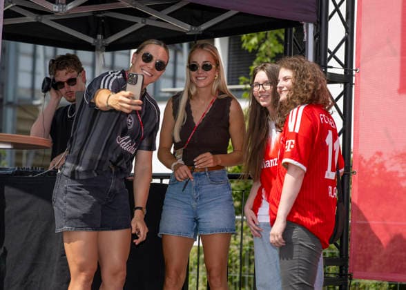 09.08.2026, Google Pixel Frauen-Bundesliga: Testspiel FC Bayern Frauen - Paris FC, im Sportpark Unterhaching, Fanfest vor dem Stadion, Meet and Greet mit den Spielerinnen Vaness Gilles (li, FC Bayern) und Giulia Gwinn (mitte, FC Bayern) und den Fans . *** August 9, 2026, Google Pixel Women s Bundesliga Friendly Match: FC Bayern Women vs. Paris FC, at Sportpark Unterhaching, fan festival in front of the stadium, meet-and-greet with players Vaness Gilles (left), FC Bayern, and Giulia Gwinn (center), FC Bayern, and the fans