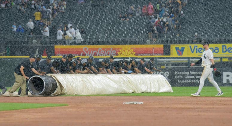 The Chicago White Sox ground crew roll out the tarp as the rain starts coming down at the end of the first inning against Cleveland Guardians at Rate Field in Chicago, IL on Sunday, August 9, 2026.  CHI20260809111 MARKxBLACK