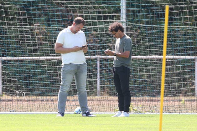 Training der Sportfreunde Siegen. Geschaeftsfuehrer (Geschäftsführer) Matthias Georg (SI) li. und Sportdirektor Nico Michaty (SI) schauen auf ihr Smartphone. Fussball Regionalliga West, Training, Sportfreunde Siegen, am 10.08.2026 in Mudersbach Deutschland. *** Training session for Sportfreunde Siegen: Managing Director Matthias Georg SI li and Sports Director Nico Michaty SI look at their smartphones. Regional League West soccer, training, Sportfreunde Siegen, on August 10, 2026, in Mudersbach, Germany