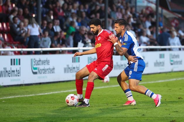12.08.2026, Fussball, Herren, Regionalliga Nord, 16. Spieltag, FC Eintracht Norderstedt - BSV Kickers Emden Semin Kojic (blau 10 BSV Kickers Emden) im Zweikampf mit Erjanik Ghubasaryan (23 FC Eintracht Norderstedt) *** August 12, 2026, Soccer, Men s, Regionalliga Nord, Matchday 16, FC Eintracht Norderstedt vs. BSV Kickers Emden, Semin Kojic (blue, 10) of BSV Kickers Emden in a tackle with Erjanik Ghubasaryan (23) of FC Eintracht Norderstedt
