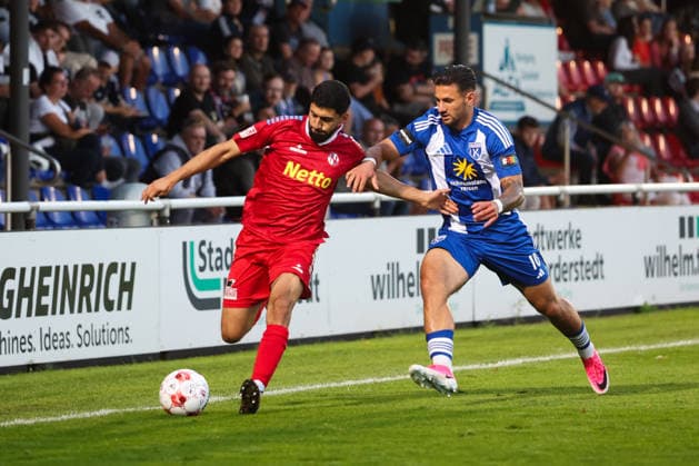 12.08.2026, Fussball, Herren, Regionalliga Nord, 16. Spieltag, FC Eintracht Norderstedt - BSV Kickers Emden Semin Kojic (blau 10 BSV Kickers Emden) im Zweikampf mit Erjanik Ghubasaryan (23 FC Eintracht Norderstedt) *** August 12, 2026, Soccer, Men s, Regionalliga Nord, Matchday 16, FC Eintracht Norderstedt vs. BSV Kickers Emden, Semin Kojic (blue, 10) of BSV Kickers Emden in a tackle with Erjanik Ghubasaryan (23) of FC Eintracht Norderstedt