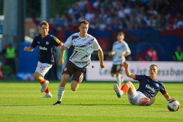 Martijn Kaars ( 19; FC St. Pauli) treibt den Ball nach einem Zweikampf mit einem gleitenden Kieler Verteidiger ( 40; KSV Holstein Kiel) voran. Im Hintergrund verfolgt ein weiterer Kieler Spieler die Szene im Holstein-Stadion. Martijn Kaars ( 19; FC St. Pauli) setzt sich gegen Holstein Kiel durch *** Martijn Kaars (19, FC St. Pauli) drives the ball forward after a tackle with a sliding Kiel defender (40, KSV Holstein Kiel). In the background, another Kiel player watches the action at Holstein Stadium. Martijn Kaars (19, FC St. Pauli) breaks through against Holstein Kiel. Copyright: xspeedshotx xAndreasxTolksdorfx