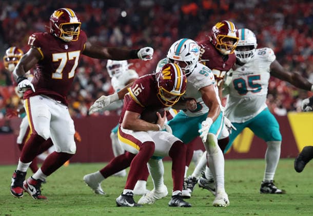 August 14, 2026, Landover, Maryland, USA: Washington Commanders quarterback Athan Kaliakmanis (16) is tackled during the NFL, American Football Herren, USA preseason game between the Washington Commanders and Miami Dolphins at Northwest Stadium on Friday, August 14, 2026; Landover, Maryland, USA. Landover USA - ZUMAs325 20260814_zsp_s325_123 Copyright: xJessxStilesx