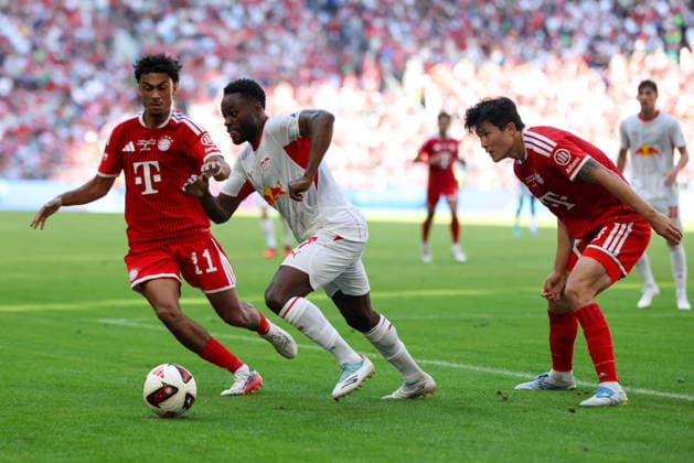 Ridle Baku (RB Leipzig, 17) mit Ball mit Nathaniel Brown (FC Bayern Muenchen, 11) und Minjae Kim (FC Bayern Muenchen, 03), GER, FC Bayern Muenchen vs. RB Leipzig, Fussball, Telekom Cup, Testspiel, Saison 2026 2027, 15.08.2026, GER, FC Bayern Muenchen vs. RB Leipzig, Fussball, Telekom Cup, Testspiel, Saison 2026 2027, 15.08.2026 Muenchen *** Ridle Baku (RB Leipzig), 17, with the ball alongside Nathaniel Brown (FC Bayern Munich), 11, and Minjae Kim (FC Bayern Munich), 03, GER, FC Bayern Munich vs. RB Leipzig, Soccer, Telekom Cup, Friendly, 2026–2027 Season, August 15, 2026, GER, FC Bayern Munich vs. RB Leipzig, soccer, Telekom Cup, friendly match, 2026–2027 season, August 15, 2026, Munich Copyright: xEibner-Pressefoto JennixMaulx EP_JML