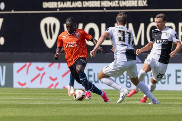 Im Bild: v.li. Jean-Victor Makengo (FC Lorient, 17) am Ball gegen Maximilian Rohr (SV 07 Elversberg, 31) und Lukas Petkov (SV 07 Elversberg, 25) 15.08.2026, 1. Bundesliga, Testspiel, SV 07 Elversberg - FC Lorient, Deutschland, Spiesen-Elversberg, URSAPHARM-Arena, DFL REGULATIONS PROHIBIT ANY USE OF PHOTOGRAPHS AS IMAGE SEQUENCES AND OR QUASI-VIDEO. *** Pictured from left: Jean Victor Makengo (FC Lorient, 17) with the ball against Maximilian Rohr (SV 07 Elversberg, 31) and Lukas Petkov (SV 07 Elversberg, 25), August 15, 2026, 1st Bundesliga, Friendly Match, SV 07 Elversberg vs. FC Lorient, Germany, Spiesen Elversberg, URSAPHARM Arena, DFL REGULATIONS PROHIBIT ANY USE OF PHOTOGRAPHS AS IMAGE SEQUENCES AND OR QUASI-VIDEO Copyright: HMBxMedia xJulienxBecker