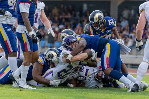 Albert Wiesigstrauch (Vienna Vikings, 22) is brought to the ground and wrapped up by multiple Alpine Rams defenders during a rushing play. Vienna Vikings at Alpine Rams, American Football, American Football League Europe, Week 13, 2026, 8.8.2026, Copyright: xPFA RicoxDoninellix