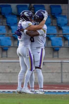 Vienna Vikings players celebrate together on the field during a game. The athletes embrace in jubilation. In the background, rows of blue stadium seats rise above a running track and artificial turf. Vienna Vikings at Alpine Rams, American Football, American Football League Europe, Week 13, 2026, 8.8.2026, Copyright: xPFA RicoxDoninellix
