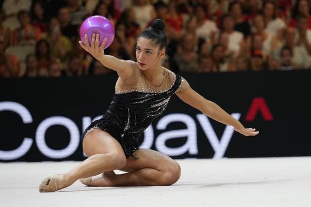 Die Italienische Gymnastin führt eine Bodenübung mit dem Ball in der Festhalle Frankfurt aus, dabei sitzt sie tief auf dem Boden und streckt den Ball mit ausgestrecktem Arm nach oben. Im Hintergrund ist das gefüllte Publikum sowie eine Werbebande sichtbar. Gymnastin aus Italien mit Ball bei der Weltmeisterschaft der rhythmischen Sportgymnastik in Frankfurt *** The Italian gymnast is performing a floor routine with a ball at the Festhalle in Frankfurt, sitting low to the floor and extending the ball upward with her arm outstretched. In the background, the packed audience and an advertising banner are visible. Italian gymnast with a ball at the Rhythmic Gymnastics World Championships in Frankfurt Copyright: xspeedshotx