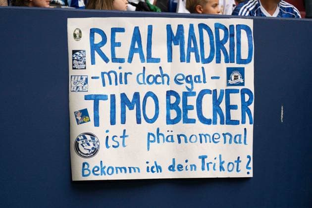 Sport Bilder des Tages 16.08.2026: Fußball: FC Schalke 04 - Real Madrid, Testspiel in der Veltins Arena Gelsenkirchen. Schild Fans Schalke 04 Timo Becker (Schalke 04, 5) WICHTIGER HINWEIS: Gemäß den Vorgaben der DFL und des DFB ist es untersagt, in dem Stadion und oder vom Spiel angefertigte Fotoaufnahmen in Form von Sequenzbildern und oder videoähnlichen Fotostrecken zu verwerten bzw. verwerten zu lassen. *** August 16, 2026: Soccer – FC Schalke 04 vs. Real Madrid, friendly match at the Veltins Arena in Gelsenkirchen; Schalke 04 fans holding a sign; Timo Becker, Schalke 04, 5 IMPORTANT NOTICE: In accordance with the regulations of the DFL and the DFB, it is prohibited to use or allow the use of photographs taken in the stadium and or during the game in the form of sequential images and or video-like photo series. Copyright: xJamesxZabelx