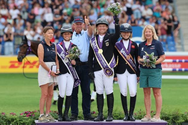 Siegerehrung Einzel, Reiter und Ihre Pferdebesitzer, 1. Patz, Weltmeister, Michael Jung (GER, Deutschland, Germany) mit Vater Joachim Jung mit Daumen hoch, Pferd fischerChipmunk FRH, Chipmunk FRH, 2. Platz Rosalind Canter (GBR, Grossbritanien, Great Britain) Pferd Lordships Graffalo, Laura Collett (GBR, Grossbritanien, Great Britain) mit Pferd London 52, Vielseitigkeit , FEI Eventing World Championship, WM, Weltmeisterschaft , DHL-Preis, Einzel Mannschaft, AACHEN - FEI World Championships 2026, Weltfest des Pferdesports, Reitsport Weltmeisterschaft 2026, Aachen 2026, Welcome Home 2026, Aachener Soers, 11. bis 23. August 2026, Reitsport, 16.08.2026, Aachen Aachener Soers Deutschland *** Awards Ceremony for Individual Events: Riders and Their Horse Owners, 1st Place, World Champion, Michael Jung GER, Germany, with his father Joachim Jung giving a thumbs-up, riding fischerChipmunk FRH, 2nd Place Rosalind Canter GBR, Great Britain, riding Lordships Graffalo, Laura Collett GBR, Great Britain, with horse London 52, Eventing, FEI Eventing World Championship, DHL Prize, Individual and Team, AACHEN FEI World Championships 2026, World Festival of Equestrian Sports, 2026 Equestrian World Championships, Aachen 2026, Welcome Home 2026, Aachen Soers, August 11–23, 2026, Equestrian Sports, August 16, 2026, Aachen Soers, Germany