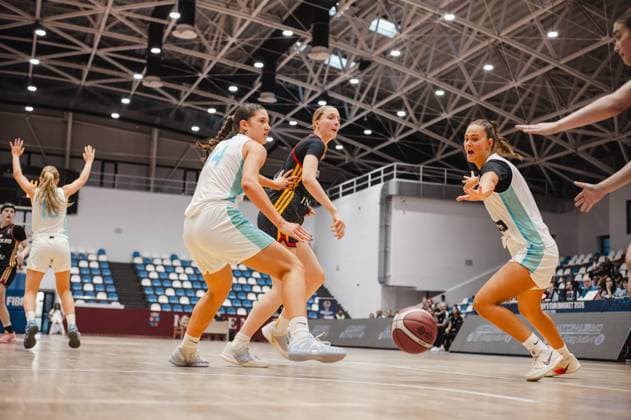Eine Spielerin von Deutschland u16w (schwarz-rot-goldenes Trikot) kämpft sich zwischen zwei Spielerinnen Slovenias (weiß-hellblau) durch, der Ball liegt lose auf dem Parkett. Die Szene zeigt intensiven Körperkontakt in der Pitesti Arena beim FIBA Women s Eurobasket 2026. Deutschland u16w im Zweikampf gegen Slovenia bei FIBA Eurobasket 2026 *** A player from Germany s U16 Women s team, wearing a black, red, and gold jersey, fights her way through between two players from Slovenia wearing white and light blue jerseys, with the ball lying loose on the court. The scene shows intense physical contact at the Pitesti Arena during the 2026 FIBA Women’s EuroBasket, as Germany’s U16 women’s team faces off against Slovenia at the 2026 FIBA EuroBasket. Copyright: xJoelxKruehlerx