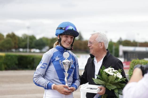 Eine Jockeyfahrerin in blauem Dress hält lächelnd einen Siegerpokal in den Händen, neben ihr steht ein älterer Herr mit Blumenstrauß und Geschenkbox. Die Siegerehrung findet auf der Rennbahn Berlin Mariendorf statt. Jockeysieger mit Pokal bei Siegerehrung auf der Rennbahn Berlin Mariendorf *** A female jockey in a blue outfit smiles as she holds a winner s trophy; standing next to her is an elderly gentleman with a bouquet of flowers and a gift box. The award ceremony is taking place at the Berlin Mariendorf Racetrack. Winning jockey with trophy at the award ceremony at the Berlin Mariendorf Racetrack Copyright: xspeedshotx