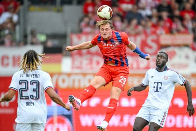Sacha Boey (FC Bayern Muenchen), Mikkel Kaufmann (1. FC Heidenheim 1846) und Dayot Upamecano (FC Bayern Muenchen) battle for the ball during the pre-Season Friendly match between 1.FC Heidenheim v FC Bayern Muenchen at Voith-Arena on August 18, 2026 in Heidenheim, Germany. (Photo by Harry Langer DeFodi Images) - *** Sacha Boey of FC Bayern Munich, Mikkel Kaufmann of 1. FC Heidenheim 1846, and Dayot Upamecano of FC Bayern Munich battle for the ball during the preseason friendly match between 1. FC Heidenheim and FC Bayern Munich at the Voith Arena on August 18, 2026 in Heidenheim, Germany. Photo by Harry Langer, DeFodi Images