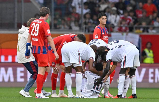 Jamal Musiala FC Bayern Muenchen FCB (10) bricht erneut auf dem Platz zusammen Zusammenbruch verletzt Verletzung Erschöpfung Kollegen eilen zu Hilfe 1. FC Heidenheim 1846 FCH vs FC Bayern Muenchen FCB TESTSPIEL 18.08.2026 DFL REGULATIONS PROHIBIT ANY USE OF PHOTOGRAPHS AS IMAGE SEQUENCES AND OR QUASI-VIDEO 1. FC Heidenheim 1846 FCH vs FC Bayern Muenchen FCB TESTSPIEL *** Jamal Musiala, FC Bayern Munich (FCB) No. 10, collapses on the field again; collapse, injury, exhaustion; teammates rush to his aid; 1. FC Heidenheim 1846 (FCH) vs. FC Bayern Munich (FCB), Friendly Match, August 18, 2026; DFL REGULATIONS PROHIBIT ANY USE OF PHOTOGRAPHS AS IMAGE SEQUENCES AND OR QUASI-VIDEO 1 FC Heidenheim 1846 FCH vs. FC Bayern Munich FCB FRIENDLY MATCH