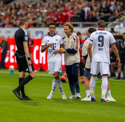 18.08.2026, Fussball Bundesliga 2026 2027, Testspiel, 1.FC Heidenheim - FC Bayern München, in der Voith-Arena Heidenheim, nach seinem erneuten Zusammenbruch während des Spieles, wird Jamal Musiala (mitte, Bayern München) vom Mannschaftsarzt Prof. Dr. Peter Ueblacker versorgt und vom Platz geführt. *** August 18, 2026, 2026–2027 Bundesliga season, friendly match, 1. FC Heidenheim vs. FC Bayern Munich, at the Voith Arena in Heidenheim; after collapsing again during the game, Jamal Musiala (center), of Bayern Munich, is treated by team doctor Prof. Dr. Peter Ueblacker and led off the field
