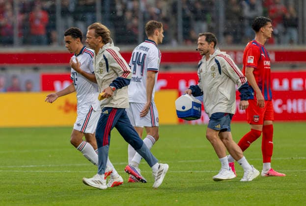 18.08.2026, Fussball Bundesliga 2026 2027, Testspiel, 1.FC Heidenheim - FC Bayern München, in der Voith-Arena Heidenheim, nach seinem erneuten Zusammenbruch während des Spieles, wird Jamal Musiala (li, Bayern München) vom Mannschaftsarzt Prof. Dr. Peter Ueblacker versorgt und vom Platz geführt. *** August 18, 2026, 2026–2027 Bundesliga season, friendly match, 1. FC Heidenheim vs. FC Bayern Munich, at the Voith Arena in Heidenheim; after collapsing again during the game, Jamal Musiala (left), of Bayern Munich, is treated by team doctor Prof. Dr. Peter Ueblacker and led off the field