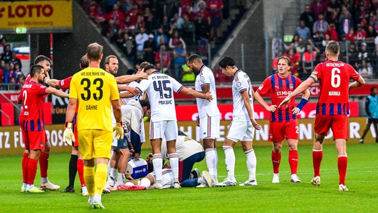 18.08.2026, GER, Fußball, Herren, FSP, 1. FC Heidenheim vs FC Bayern München Jamal Musiala (Bayern Muenchen, 10) kollabiert auf dem Rasen ohne Fremdeinwirkung, Spieler beider Mannschaften bilden anschliesend einen Sichtschutz Heidenheim Voith-Arena Baden-Württemberg Deutschland *** August 18, 2026, GER, Soccer, Men s, FSP, 1 FC Heidenheim vs. FC Bayern Munich: Jamal Musiala (Bayern Munich, No. 10) collapses on the field without any outside influence; players from both teams then form a screen to block the view. Heidenheim Voith Arena, Baden-Württemberg, Germany Copyright: xNordphotox xHafnerx