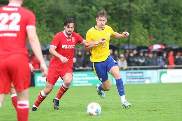 Gianluca Swajkowski ( 39; Rot-Weiss Essen) setzt sich im Zweikampf gegen einen Spieler des SV Sonsbeck durch, während der Ball vor ihm liegt. Im Hintergrund verfolgen zahlreiche Zuschauer das Spiel im Regen im Willi-Lemkens Sportpark in Sonsbeck. Gianluca Swajkowski ( 39; Rot-Weiss Essen) im Zweikampf gegen SV Sonsbeck *** Gianluca Swajkowski, 39, of Rot-Weiss Essen, wins a tackle against an SV Sonsbeck player while the ball lies in front of him. In the background, numerous spectators watch the game in the rain at Willi Lemkens Sportpark in Sonsbeck. Gianluca Swajkowski, 39, of Rot-Weiss Essen, in a tackle against SV Sonsbeck Copyright: xspeedshotx xTimoxBluhmki-Schmidtx
