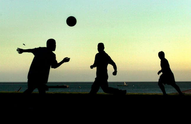 Reportage om fotboll i USA. Med ett par soptunnor som malstolpar spelar en blandad skara pojkar och män fotboll pa en gräsmatta vid havet i Long Beach. Genrebild. Los Angeles Usa *** Feature story on soccer in the U.S. Using a couple of trash cans as goalposts, a mixed group of boys and men play soccer on a lawn by the ocean in Long Beach. Stock photo, Los Angeles, U.S.  Copyright: xNiklasxLarssonx