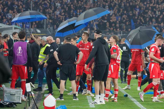 Im Bild: Fans bewerfen die Spieler vom 1. FC Kaiserslautern mit Baechern. Regenschirme mussten ausgeklappt werden. 21.08.2026, SV Waldhof Mannheim 07 - 1. FC Kaiserslautern, DFB-Pokal, 1. Runde, Deutschland, Mannheim, Carl-Benz-Stadion, DFL REGULATIONS PROHIBIT ANY USE OF PHOTOGRAPHS AS IMAGE SEQUENCES AND OR QUASI-VIDEO. *** In the photo, fans are throwing bottles at the players of 1 FC Kaiserslautern; umbrellas had to be opened. August 21, 2026, SV Waldhof Mannheim 07 vs. 1 FC Kaiserslautern, DFB Cup, First Round, Germany, Mannheim, Carl Benz Stadium, DFL regulations prohibit any use of photographs as image sequences and or quasi-video Copyright: HMBxMedia xJulienxBecker
