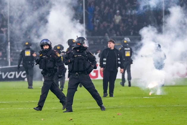 Polizisten sichern das Spielfeld nach Pyroattacken von den Rängen, Erhöhtes Polizeiaufkommen bei der Partie, Polizisten im Stadion, Polizeipräsenz, Polizeischutz, Polizei im Einsatz, Sicherheit, Stadionsicherheit, Symbolfoto, Symbolbild, Symbol, Risikospiel, Hochsicherheitsspiel, Fußballspiel mit einem erhöhten Sicherheitsrisiko, das Spiel wurde im Vorfeld als Hochrisikospiel eingestuft, 21.08.2026, Mannheim (Deutschland), Fussball, DFB-Pokal, 1. Runde, SV Waldhof Mannheim - 1. FC Kaiserslautern, DFB DFL REGULATIONS PROHIBIT ANY USE OF PHOTOGRAPHS AS IMAGE SEQUENCES AND OR QUASI-VIDEO. *** Police officers secure the field after pyrotechnic attacks from the stands; increased police presence at the game; police officers in the stadium; police presence, police protection, police in action, security, stadium security, stock photo, stock image, symbol, high-risk game, high-security game, soccer game with an increased security risk, the game was classified as a high-risk game in advance, August 21, 2026, Mannheim, Germany, soccer, DFB Cup, 1st round, SV Waldhof Mannheim vs. 1. FC Kaiserslautern, DFB and DFL regulations prohibit any use of photographs as image sequences and or quasi-video xozx