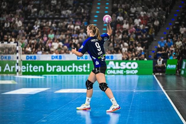 Nieke Kühne ( 9; HSG Blomberg-Lippe) holt mit dem Ball in der erhobenen Hand zum Wurf aus, im Hintergrund ist das vollbesetzte Publikum des SAP Garden München zu sehen. Die Spielerin trägt Knieschoner und ist von hinten fotografiert. Nieke Kühne ( 9; HSG Blomberg-Lippe) beim Wurfansatz im SAP Garden *** Nieke Kühne 9 of HSG Blomberg Lippe winds up to shoot with the ball held aloft, with the packed crowd at SAP Garden Munich visible in the background. The player is wearing knee pads and is photographed from behind. Nieke Kühne 9 of HSG Blomberg Lippe prepares to shoot at SAP Garden. Copyright: xspeedshotx xDorianfrickx