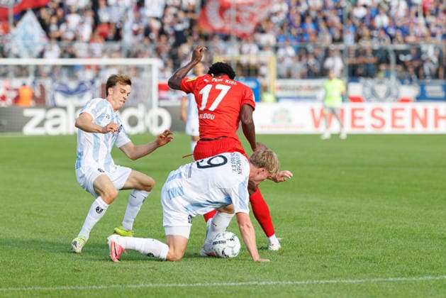 Fabio Wagner (9, TSV 1860 München) und Faride Alidou (17, Holstein Kiel) beim Spiel zwischen TSV 1860 München v Holstein Kiel, Fussball, Herren, Dfb Pokal, 2026 2027, 1.Runde am 22.08.2026 in München, Städtisches Stadion an der Grünwalder Straße. Bayern Deutschland *** Fabio Wagner, 9, TSV 1860 Munich, and Faride Alidou, 17, Holstein Kiel, during the match between TSV 1860 Munich and Holstein Kiel, soccer, men s, DFB Cup, 2026–2027, First Round on August 22, 2026, in Munich, Municipal Stadium on Grünwalder Straße, Bavaria, Germany