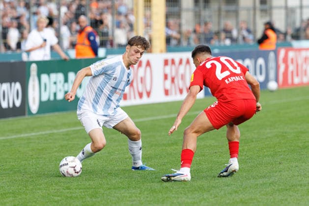 Emre Erdogan (19, TSV 1860 München) und Adrian Kapralik (20, Holstein Kiel) beim Spiel zwischen TSV 1860 München v Holstein Kiel, Fussball, Herren, Dfb Pokal, 2026 2027, 1.Runde am 22.08.2026 in München, Städtisches Stadion an der Grünwalder Straße. Bayern Deutschland *** Emre Erdogan, 19, TSV 1860 Munich, and Adrian Kapralik, 20, Holstein Kiel, during the match between TSV 1860 Munich and Holstein Kiel, soccer, men s, DFB Cup, 2026–2027, First Round on August 22, 2026, in Munich, Städtisches Stadion an der Grünwalder Straße, Bavaria, Germany