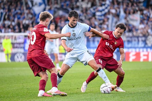 Lukas Stopel (SG Sonnenhof Grossaspach), Maximilian Bauer (Arminia Bielefeld) und Niklas Pollex (SG Sonnenhof Grossaspach) im Zweikampf waehrend des DFB-Pokal 1 Runde Spiels zwichen SG Sonnenhof Grossaspach v Arminia Bielefeld, Wir machen Druck Arena am 22. August 2026 in Grossaspach, Deutschland. (Foto von Harry Langer DeFodi Images) +++ Lukas Stopel (SG Sonnenhof Grossaspach), Maximilian Bauer (Arminia Bielefeld) und Niklas Pollex (SG Sonnenhof Grossaspach) battle for the ball during the DFB-Pokal 1 Runde match between SG Sonnenhof Grossaspach v Arminia Bielefeld at Wir machen Druck Arena on August 22, 2026 in Grossaspach, Germany. (Photo by Harry Langer DeFodi Images) (Photo by Harry Langer DeFodi Images) DFB DFL REGULATIONS PROHIBIT ANY USE OF PHOTOGRAPHS AS IMAGE SEQUENCES AND OR QUASI-VIDEO. - *** Lukas Stopel of SG Sonnenhof Grossaspach, Maximilian Bauer of Arminia Bielefeld, and Niklas Pollex of SG Sonnenhof Grossaspach in a one-on-one battle during the DFB Cup first-round match between SG Sonnenhof Grossaspach and Arminia Bielefeld, Wir machen Druck Arena on August 22, 2026, in Grossaspach, Germany. Photo by Harry Langer, DeFodi Images. Lukas Stopel of SG Sonnenhof Grossaspach, Maximilian Bauer of Arminia Bielefeld and Niklas Pollex of SG Sonnenhof Grossaspach battle for the ball during the DFB Cup first-round match between SG Sonnenhof Grossaspach and Arminia Bielefeld at Wir machen Druck Arena on August 22, 2026 in Grossaspach, Germany. Photo by Harry Langer, DeFodi Images. Photo by Harry Langer, DeFodi Images. DFB and DFL regulations prohibit any use of photographs as image sequences and or quasi-video.