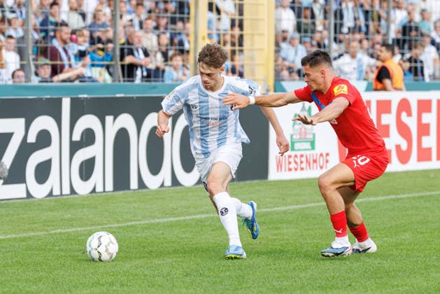 Emre Erdogan (19, TSV 1860 München) und Adrian Kapralik (20, Holstein Kiel) beim Spiel zwischen TSV 1860 München v Holstein Kiel, Fussball, Herren, Dfb Pokal, 2026 2027, 1.Runde am 22.08.2026 in München, Städtisches Stadion an der Grünwalder Straße. Bayern Deutschland *** Emre Erdogan, 19, TSV 1860 Munich, and Adrian Kapralik, 20, Holstein Kiel, during the match between TSV 1860 Munich and Holstein Kiel, soccer, men s, DFB Cup, 2026–2027, First Round on August 22, 2026, in Munich, Städtisches Stadion an der Grünwalder Straße, Bavaria, Germany