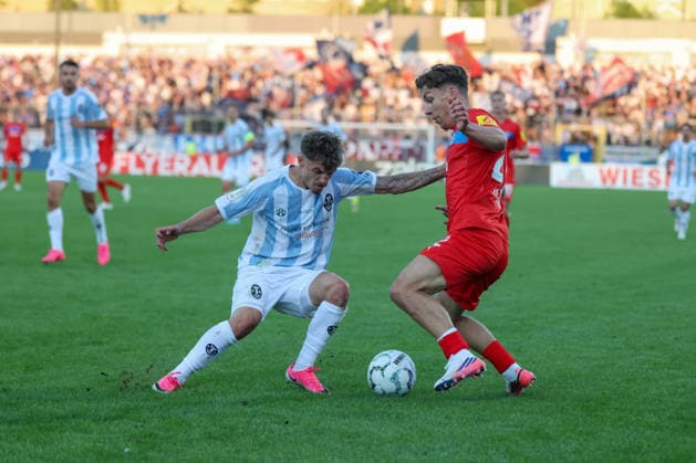 Moritz Reimers (Holstein Kiel, 22) mit Mark Grevorgyan (TSV 1860 Muenchen, 24), GER, TSV 1860 Muenchen vs. Holstein Kiel, Fussball, DFB-Pokal, 1. Runde, Saison 2026 2027, 22.08.2026, DFL REGULATIONS PROHIBIT ANY USE OF PHOTOGRAPHS AS IMAGE SEQUENCES, GER, TSV 1860 Muenchen vs. Holstein Kiel, Fussball, DFB-Pokal, 1. Runde, Saison 2026 2027, 22.08.2026 Muenchen *** Moritz Reimers, Holstein Kiel, 22, with Mark Grevorgyan, TSV 1860 Munich, 24, GER, TSV 1860 Munich vs. Holstein Kiel, Soccer, DFB Cup, 1st Round, 2026–2027 Season, August 22, 2026, DFL regulations prohibit any use of photographs as image sequences, GER, TSV 1860 Munich vs. Holstein Kiel, Soccer, DFB Cup, 1st Round, 2026–2027 Season, August 22, 2026, Munich Copyright: xEibner-Pressefoto JennixMaulx EP_JML