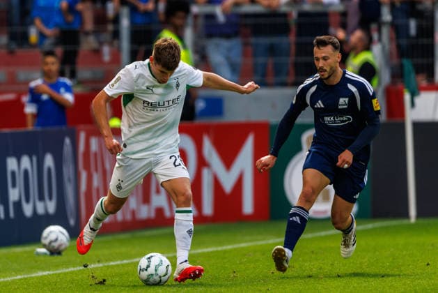 MAINZ, GERMANY - AUGUST 23: Lukas Ullrich (Borussia Moenchengladbach, 26) is challenged by Silas Schwarz (TSV Schott Mainz, 8) during the first-round match between TSV Schott Mainz vs. Borussia Moenchengladbach at MEWA Arena of the German Cup on August 23, 2026 in Mainz, Germany. DFL REGULATIONS PROHIBIT ANY USE OF PHOTOGRAPHS AS IMAGE SEQUENCES AND OR QUASI-VIDEO. Rhineland-Palatinate Germany Copyright: xStephanxHahnex