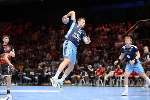 Moritz Sauter ( 33; HSV Hamburg) zieht in der Volkswagen Halle Braunschweig zum Sprungwurf hoch und hält den Ball wurfbereit über dem Kopf. Martin Hovde ( 81; HSV Hamburg) beobachtet die Szene im Hintergrund, während Tim Lietz von MTV Braunschweig links im Bild zusieht. Moritz Sauter ( 33; HSV Hamburg) beim Sprungwurf in Braunschweig *** Moritz Sauter, No. 33 of HSV Hamburg, rises for a jump shot at the Volkswagen Halle in Braunschweig, holding the ball above his head, ready to shoot, while Martin Hovde, No. 81 of HSV Hamburg, watches the action in the background, while Tim Lietz of MTV Braunschweig watches from the left side of the frame. Moritz Sauter (33) of HSV Hamburg takes a jump shot in Braunschweig Copyright: xspeedshotx