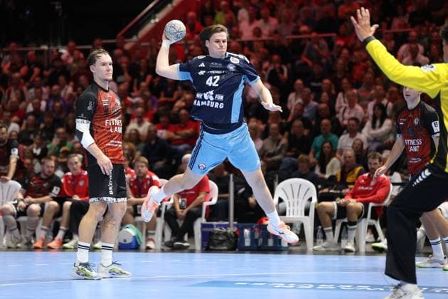 Jan Christian Schmidt ( 42; HSV Hamburg) springt ab und zieht zum Wurf auf, den Ball bereits über dem Kopf. Mika Hoyer ( 77; MTV Braunschweig) beobachtet die Aktion aus dem Hintergrund, während der MTV-Torwart den Arm hebt. Jan Christian Schmidt ( 42; HSV Hamburg) beim Sprungwurf gegen MTV Braunschweig *** Jan Christian Schmidt, 42, of HSV Hamburg jumps and prepares to shoot; the ball is already above his head. Mika Hoyer, 77, of MTV Braunschweig watches the action from behind as the MTV goalkeeper raises his arm. Jan Christian Schmidt, 42, of HSV Hamburg takes a jump shot against MTV Braunschweig. Copyright: xspeedshotx