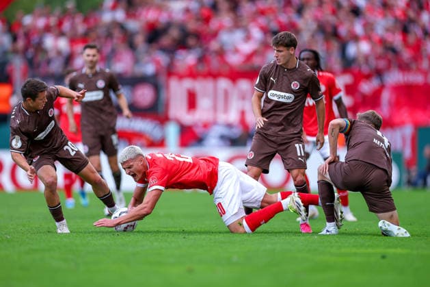 23.08.2026, Fußball, Rot-Weiss Essen - FC St. Pauli, 1. Runde DFB-Pokal 2026 27, Stadion an der Hafenstraße, Saison 2026 2027: Marek Janssen (RWE 20) unterliegt im Zweikampf gegen Mathias Rasmussen (FC St. Pauli 20) Arkadiusz Pyrka (FC St. Pauli 11) David Nemeth (FC St. Pauli 04) DFB regulations prohibit any use of photographs as image sequences and or quasi-video. Nordrhein-Westfalen Deutschland *** August 23, 2026, Soccer, Rot Weiss Essen vs. FC St. Pauli, First Round of the 2026–27 DFB Cup, Stadion an der Hafenstraße, 2026–2027 Season: Marek Janssen (RWE 20) loses a one-on-one battle against Mathias Rasmussen (FC St. Pauli 20), Arkadiusz Pyrka (FC St. Pauli 11), David Nemeth (FC St. Pauli 04). DFB regulations prohibit any use of photographs as image sequences and or quasi-video North Rhine-Westphalia, Germany
