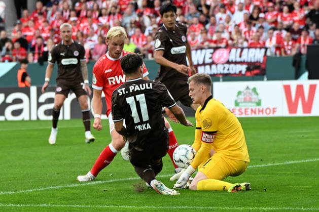 Arkadiusz Pyrka (FC St. Pauli) und Torwart Jakob Golz (Rot-Weiss Essen) im Zweikampf waehrend des DFB-Pokal Spiels zwischen Rot-Weiss Essen v FC St. Pauli, Stadion an der Hafenstrasse am 23. August 2026 in Essen, Deutschland. (Foto von Ralf Treese DeFodi Images) +++ Arkadiusz Pyrka (FC St. Pauli) und Torwart Jakob Golz (Rot-Weiss Essen) battle for the ball during the DFB-Pokal match between Rot-Weiss Essen v FC St. Pauli at Stadion an der Hafenstrasse on August 23, 2026 in Essen, Germany. (Photo by Ralf Treese DeFodi Images) (Photo by Ralf Treese DeFodi Images) - *** Arkadiusz Pyrka of FC St. Pauli and goalkeeper Jakob Golz of Rot-Weiss Essen battle for the ball during the DFB Cup match between Rot-Weiss Essen and FC St. Pauli at Stadion an der Hafenstrasse on August 23, 2026, in Essen, Germany. Photo by Ralf Treese, DeFodi Images. Arkadiusz Pyrka of FC St. Pauli and goalkeeper Jakob Golz of Rot-Weiß Essen battle for the ball during the DFB Cup match between Rot-Weiß Essen and FC St. Pauli at Stadion an der Hafenstrasse on August 23, 2026 in Essen, Germany Photo by Ralf Treese, DeFodi Images Photo by Ralf Treese, DeFodi Images