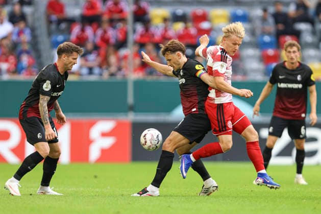 Lukas Kuebler (SC Freiburg) nd Andreas Mueller (Fortuna Duesseldorf) im Zweikampf waehrend des Spiels der 1. Runde des DFB-Pokal zwischen Fortuna Duesseldorf und SC Freiburg, Merkur Spiel-Arena am 23. August 2026 in Duesseldorf, Deutschland. (Foto von Oliver Kaelke DeFodi Images) +++ Lukas Kuebler (SC Freiburg) nd Andreas Mueller (Fortuna Duesseldorf) battle for the ball during the 1st round match of the DFB-Pokal between Fortuna Duesseldorf and SC Freiburg at Merkur Spiel-Arena on August 23, 2026 in Dusseldorf, Germany. (Photo by Oliver Kaelke DeFodi Images) DFB DFL REGULATIONS PROHIBIT ANY USE OF PHOTOGRAPHS AS IMAGE SEQUENCES AND OR QUASI-VIDEO. (Photo by Oliver Kaelke DeFodi Images) - *** Lukas Kuebler of SC Freiburg and Andreas Mueller of Fortuna Düsseldorf battle for the ball during the first-round DFB Cup match between Fortuna Düsseldorf and SC Freiburg at the Merkur Spiel Arena on August 23, 2026, in Düsseldorf, Germany. Photo by Oliver Kaelke, DeFodi Images. Lukas Kuebler of SC Freiburg and Andreas Mueller of Fortuna Düsseldorf battle for the ball during the first-round match of the DFB Cup between Fortuna Düsseldorf and SC Freiburg at Merkur Spiel Arena on August 23, 2026 in Düsseldorf, Germany. Photo by Oliver Kaelke, DeFodi Images. DFB and DFL regulations prohibit any use of photographs as image sequences and or quasi-video. Photo by Oliver Kaelke, DeFodi Images.
