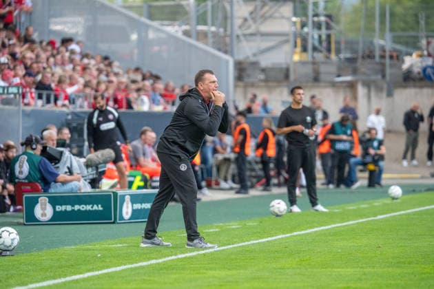 Uwe Koschinat (Rot-Weiss Essen, Cheftrainer) an der Seitenlinie, Marcel Rapp (FC St. Pauli, Cheftrainer) im Hintergrund mit Wasserflasche, GER Rot-Weiss Essen vs. FC St. Pauli, Fussball, DFB Pokal, Runde 1, Hauptrunde 2026 2027, 23.08.2026 DFB DFL REGULATIONS PROHIBIT ANY USE OF PHOTOGRAPHS AS IMAGE SEQUENCES AND OR QUASI-VIDEO, GER Rot-Weiss Essen vs. FC St. Pauli, Fussball, DFB Pokal, Runde 1, Hauptrunde 2026 2027, 23.08.2026 Essen *** Uwe Koschinat, Rot Weiss Essen, head coach on the sideline; Marcel Rapp, FC St. Pauli, head coach in the background holding a water bottle; GER Rot Weiss Essen vs. FC St. Pauli, soccer, DFB Cup, Round 1, 2026–2027 Main Round, August 23, 2026 DFB DFL regulations prohibit any use of photographs as image sequences and or quasi-video, GER Rot Weiss Essen vs. FC St. Pauli, soccer, DFB Cup, Round 1, Main Round 2026–2027, August 23, 2026, Essen Copyright: xEibner-Pressefoto FabianxFriesex EP_FFE