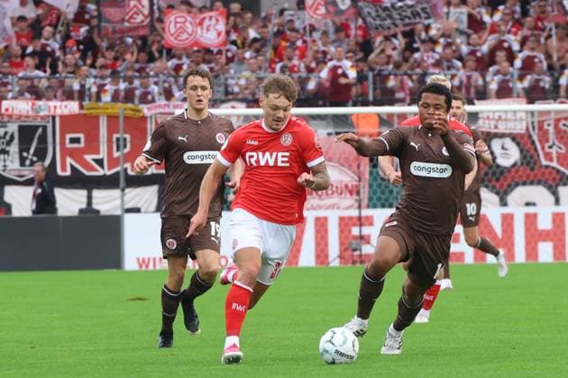 Jannik Hofmann von Rot-Weiss Essen behauptet den Ball gegen Joel Chima Fujita und Martijn Kaars vom FC St. Pauli im Stadion an der Hafenstraße. Im Hintergrund feuern die Essener Fans ihre Mannschaft lautstark an. Jannik Hofmann ( 37; Rot-Weiss Essen) im Zweikampf gegen FC St. Pauli *** Jannik Hofmann of Rot Weiss Essen wins the ball against Joel Chima Fujita and Martijn Kaars of FC St. Pauli at the Stadion an der Hafenstraße. In the background, Essen fans are loudly cheering on their team. Jannik Hofmann (No. 37), Rot Weiss Essen, in a tackle against FC St. Pauli Copyright: xspeedshotx xTimoxBluhmki-Schmidtx