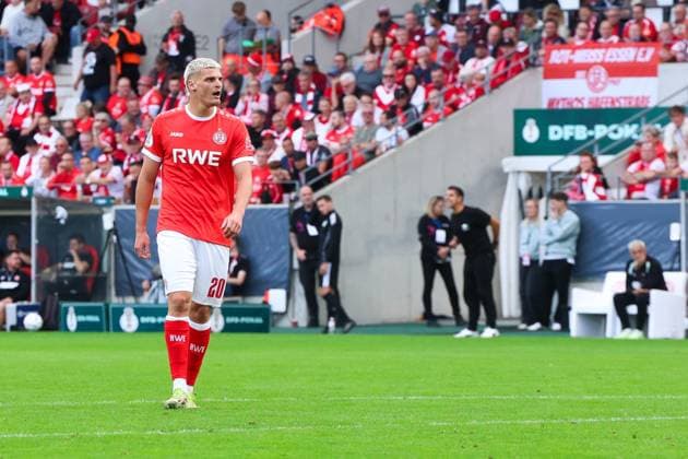 Marek Janssen ( 20; Rot-Weiss Essen) läuft konzentriert über den Rasen im Stadion an der Hafenstraße. Im Hintergrund sind die vollbesetzten Tribünen mit RWE-Fans sowie das DFB-Pokal-Banner sichtbar. Marek Janssen ( 20; Rot-Weiss Essen) im DFB-Pokal-Einsatz *** Marek Janssen, No. 20 of Rot-Weiss Essen, runs with focus across the field at the stadium on Hafenstraße. In the background, the packed stands filled with RWE fans and the DFB Cup banner are visible. Marek Janssen, No. 20 of Rot-Weiss Essen, in DFB Cup action Copyright: xRuhr.Pottraitx