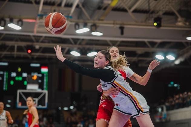Eine Spielerin der deutschen Nationalmannschaft kämpft im Zweikampf mit einer ungarischen Spielerin um den Ball, der in der Luft ist. Die Szene zeigt intensive Körperkontakt-Aktion in der Sparkassen-Arena Göttingen. Zweikampf zwischen Deutschland und Ungarn beim Basketball in Göttingen *** A player on the German national team battles a Hungarian player for the ball, which is in the air. The scene shows intense physical contact during a basketball game between Germany and Hungary at the Sparkassen Arena in Göttingen. Copyright: xJoelxKruehlerx